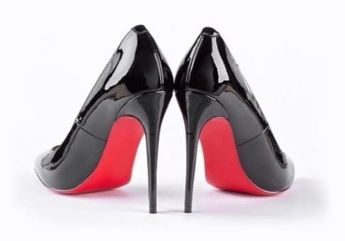 A pair of black high heels with red soles.